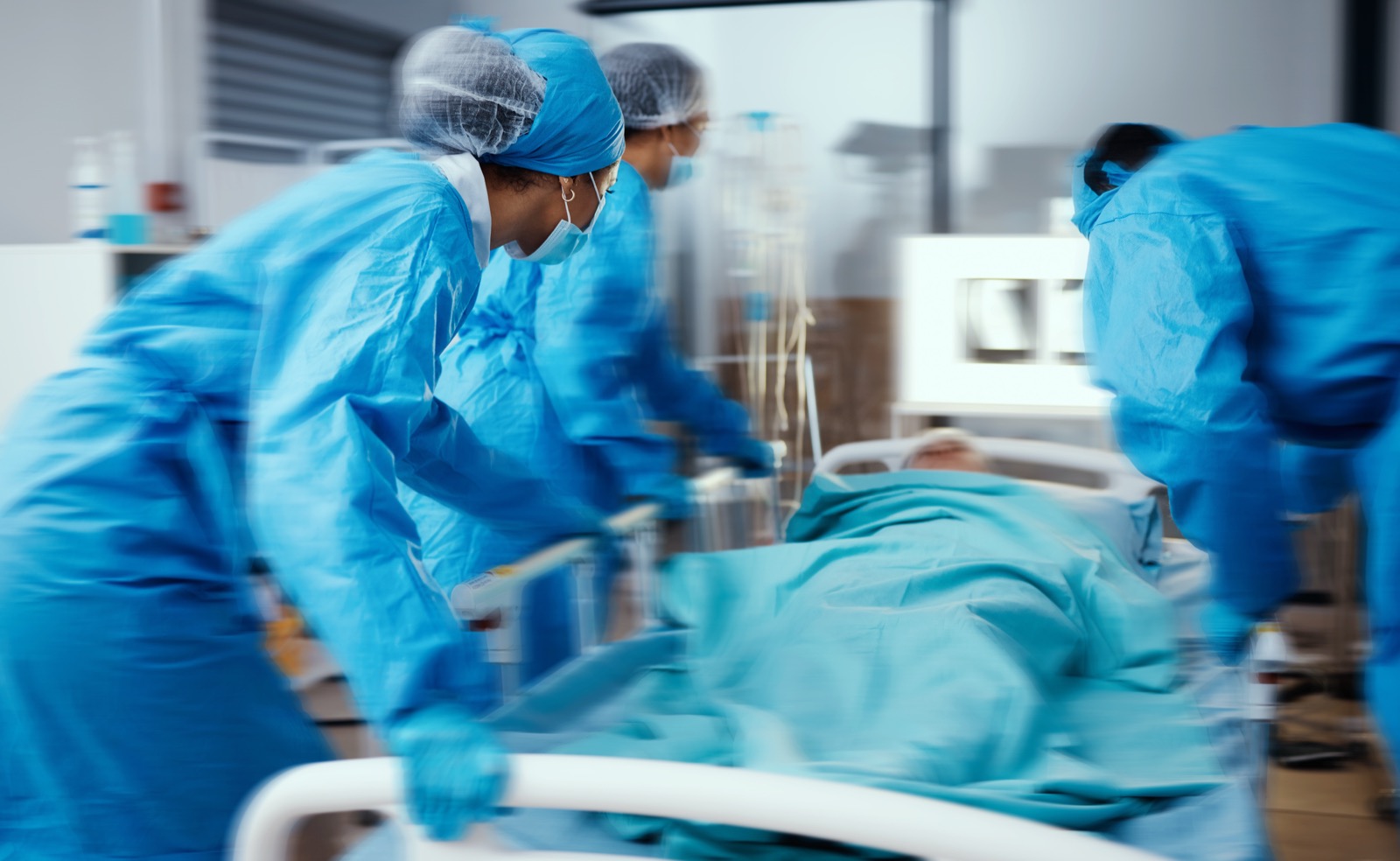 Emergency room team rushing a patient on a gurney through hospital corridors, motion blur, blue scrubs